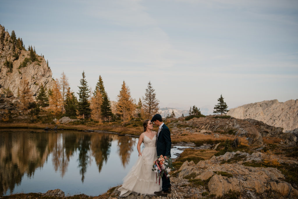 elopement photos on a mountain with larch trees and lake