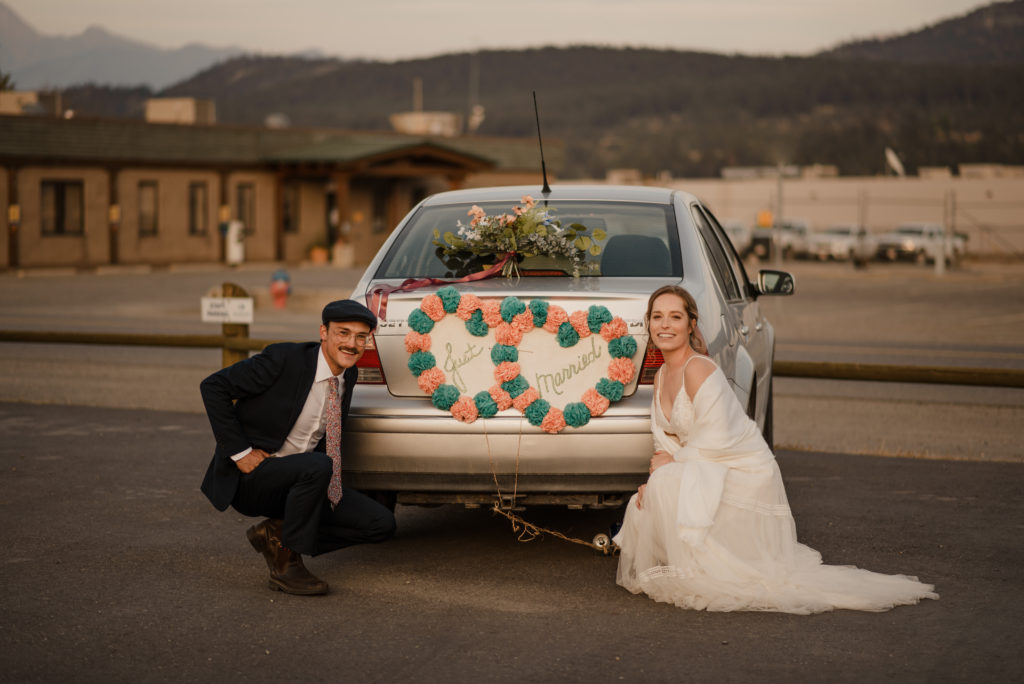 just married sign on car with bride and groom