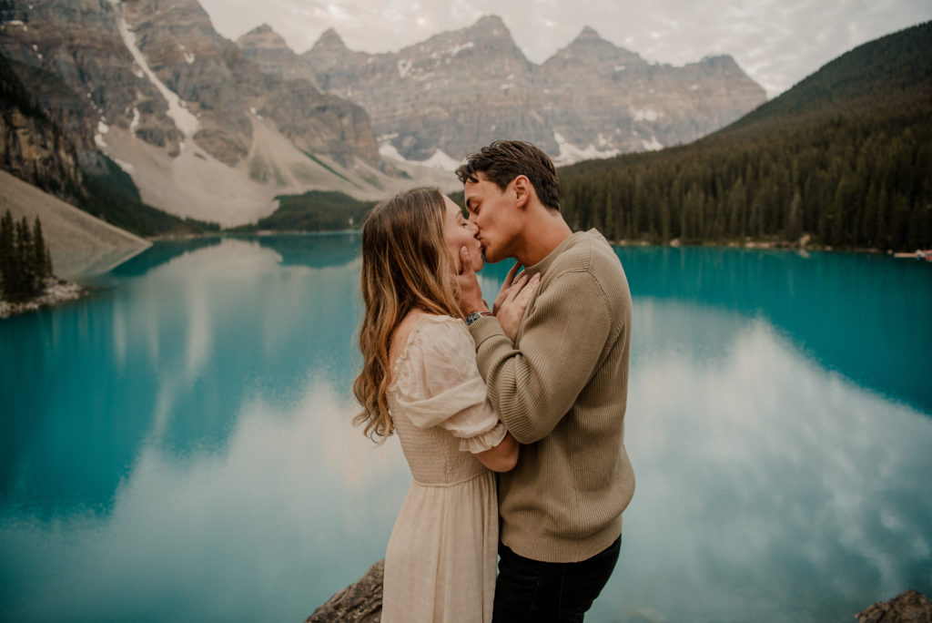 couple kissing during engagement session at moraine lake