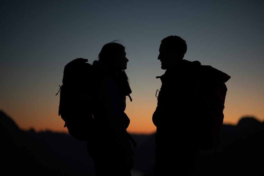 couple on top of a mountain at sunrise as a silhouette