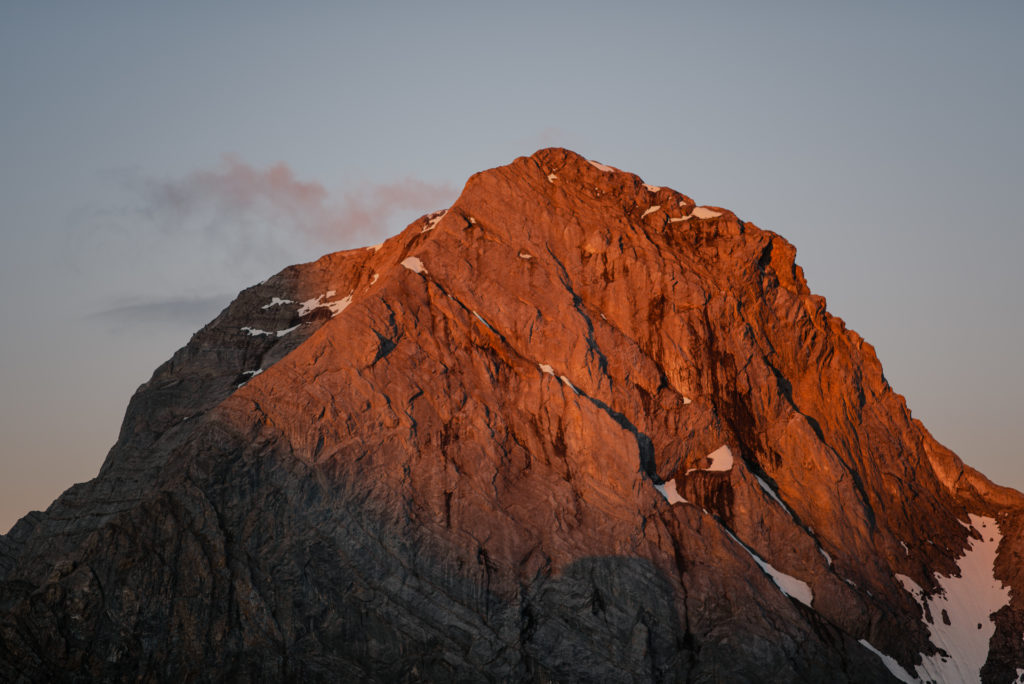 the first light of dawn creating alpenglow on the peaks