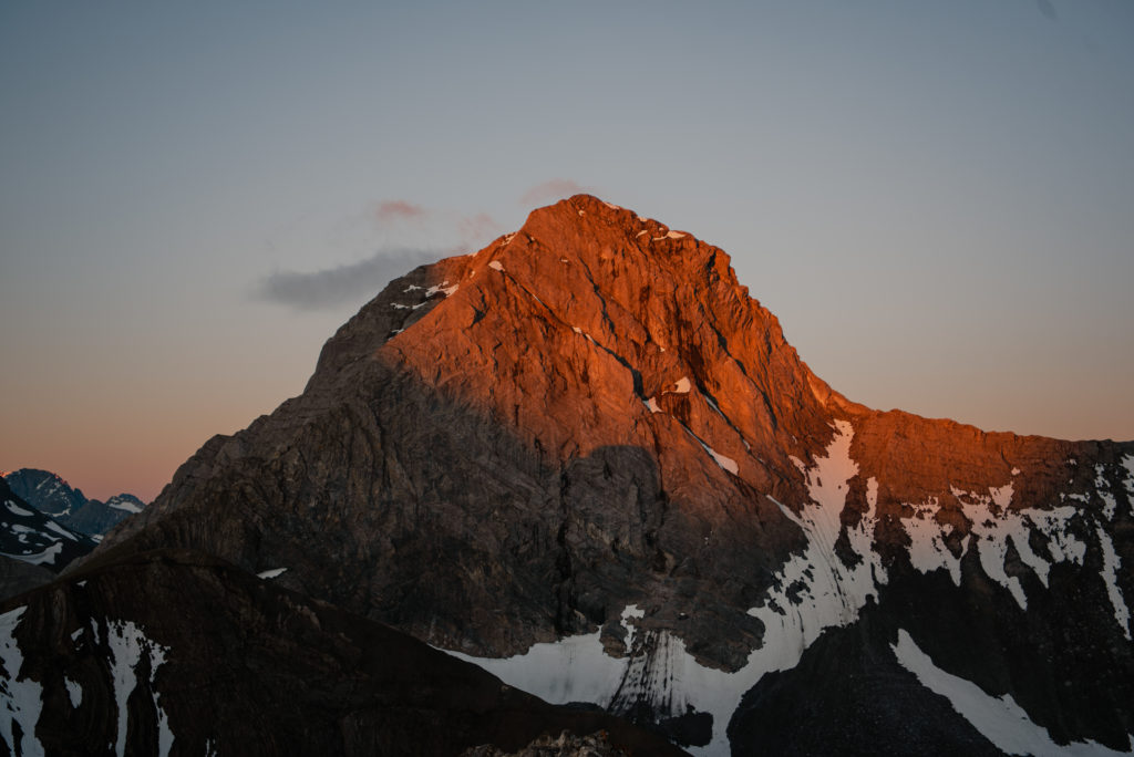 the first light of dawn creating alpenglow on the peaks