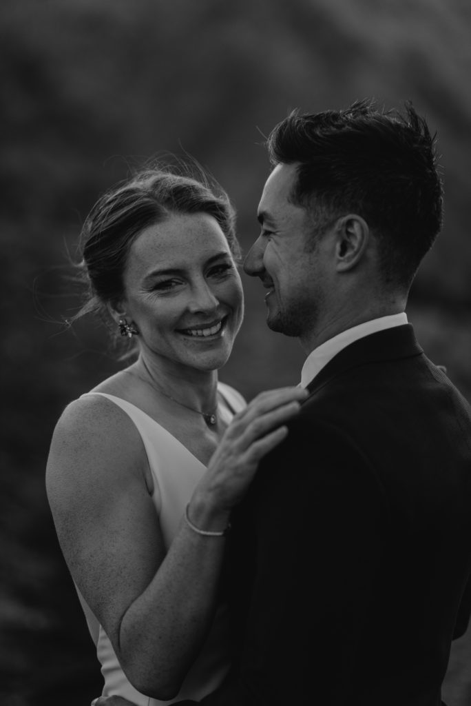 Wedding couple with big smiles closeup on top of a mountain in Kananaskis